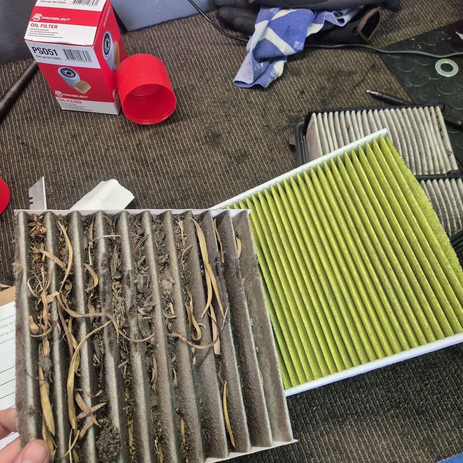 A cabin filter packed with leaves and grit held beside a clean replacement