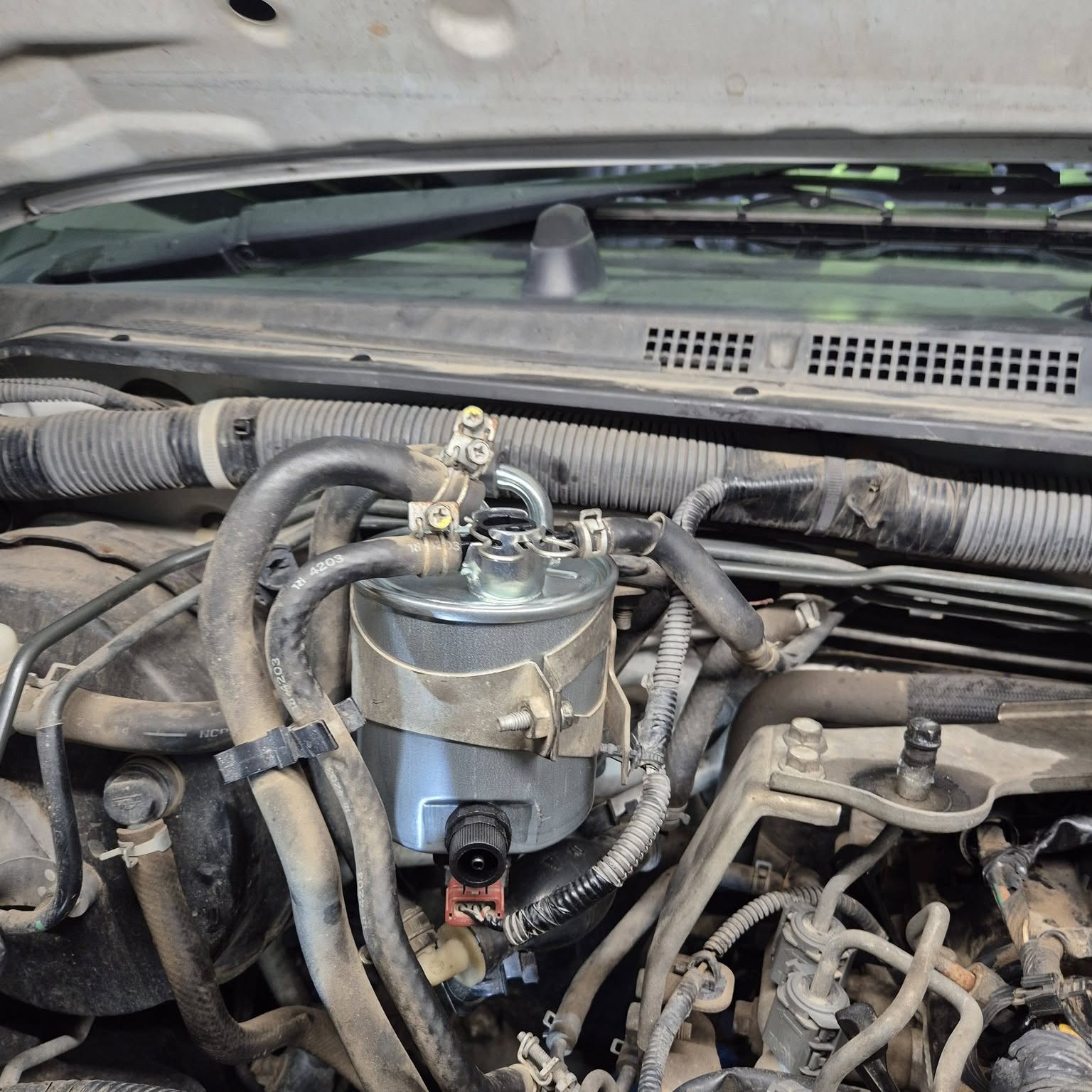 A new fuel filter fitted into an engine bay