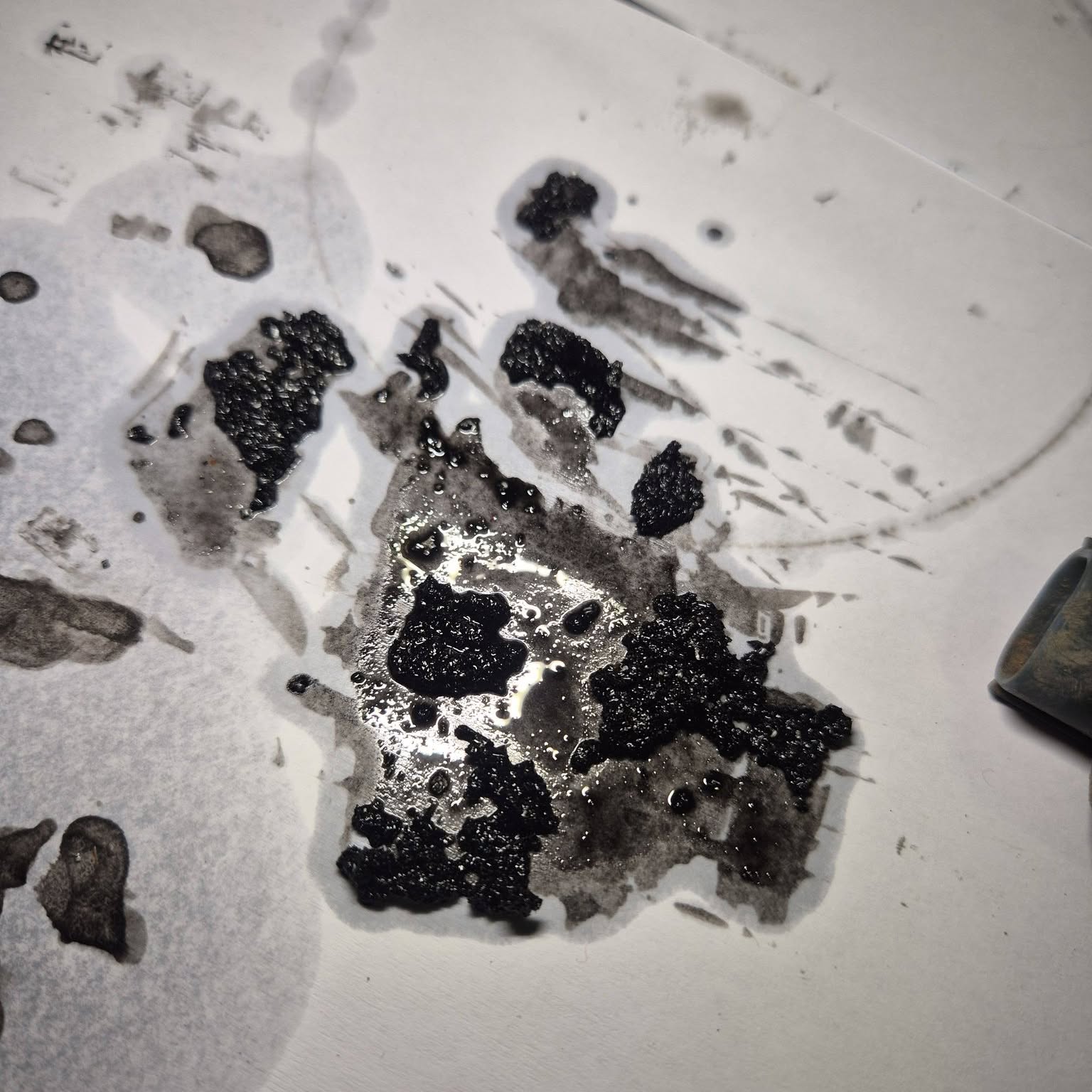 Drained oil and contaminant laid out on clean paper for inspection